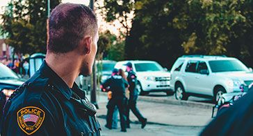 law-enforcement agencies drug test using hair and this image is off an officer watching two other officers escort a woman to their vehicle